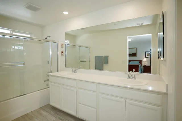 a bathroom with a bathtub shower sink and mirror