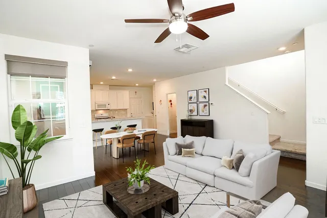 a living room with furniture kitchen view and a potted plant