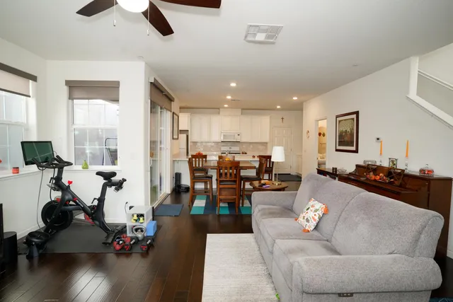 a living room with furniture kitchen view and a large window
