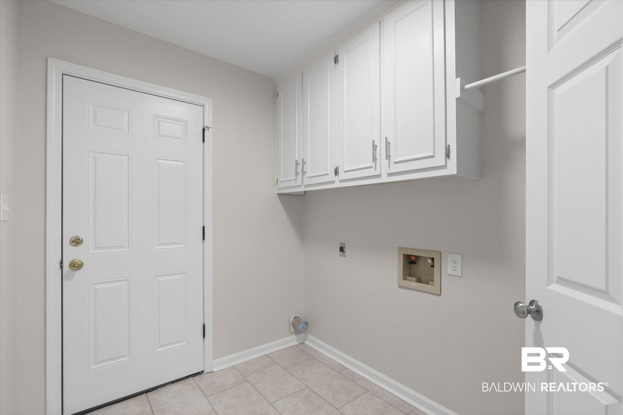 106 Melanie Loop Daphne, AL 36526 - Photo 30 of 45 Laundry area featuring electric dryer hookup, washer hookup, cabinet space, and light tile patterned floors