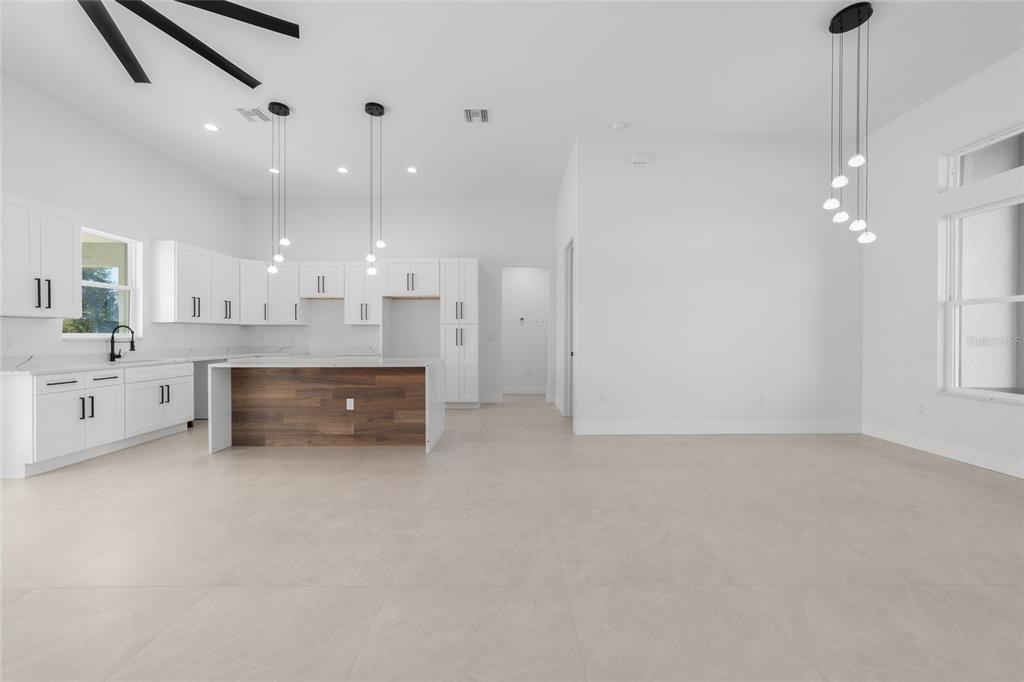 9580 Southwest 44th Avenue Ocala, FL 34476 - Photo 16 of 55 a large white kitchen with a white cabinets and chandelier