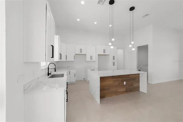 a large kitchen with a lot of counter space and wooden floor
