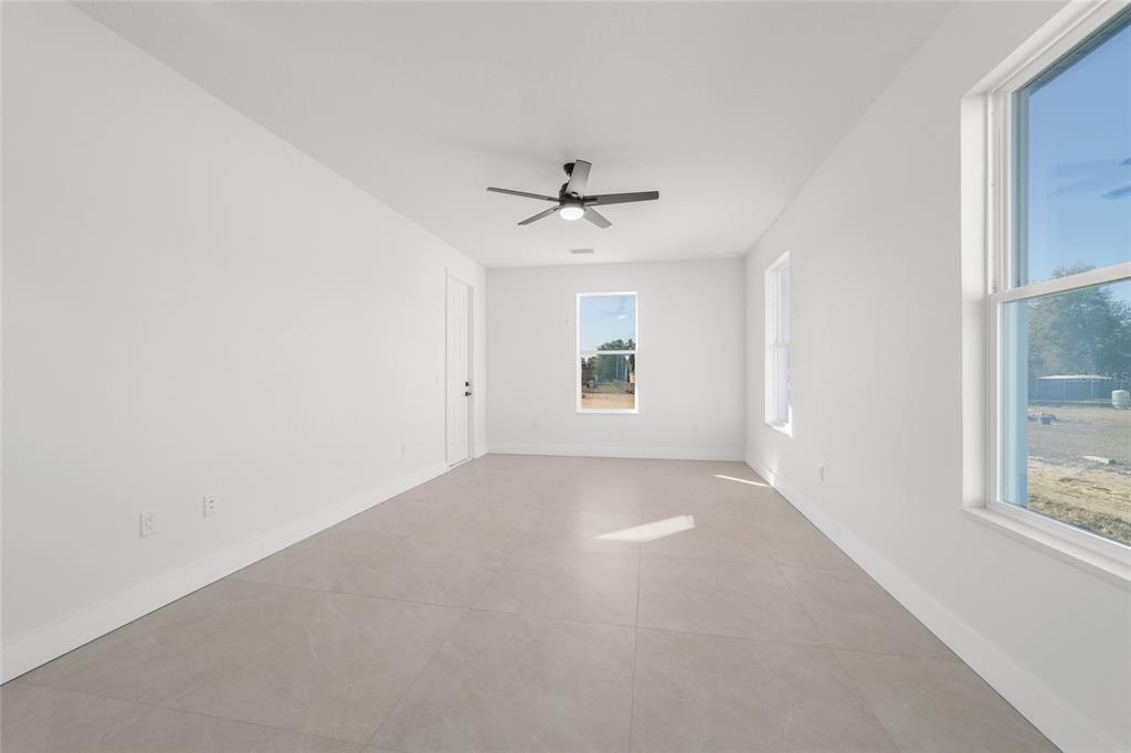 9580 Southwest 44th Avenue Ocala, FL 34476 - Photo 32 of 55 an empty room with windows and chandelier fan