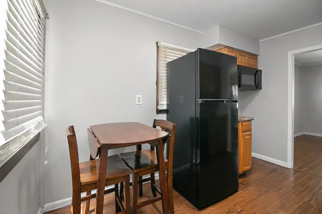 a kitchen with a refrigerator a table and chairs in it