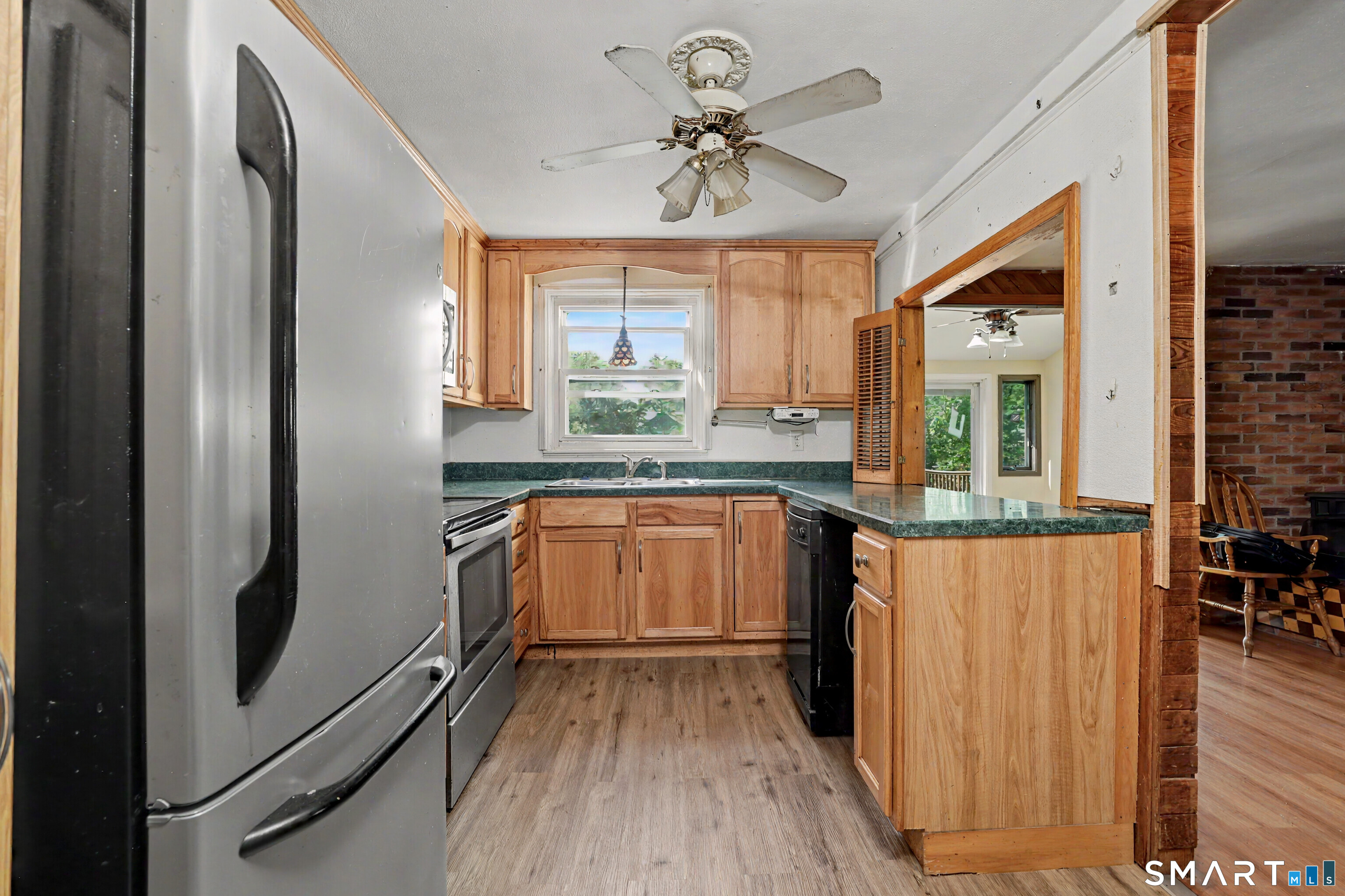 97 Boothbay Street Bloomfield, CT 06002 - Photo 10 of 33 a kitchen with a refrigerator a sink and dishwasher with wooden floor