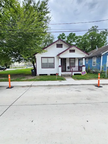 a front view of a house with a yard and potted plants