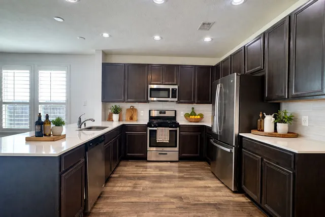 a kitchen with granite countertop stainless steel appliances and refrigerator