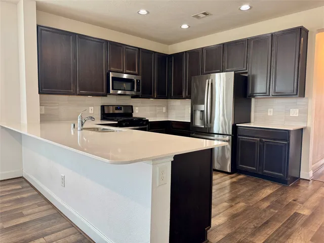 a kitchen with wooden cabinets and stainless steel appliances