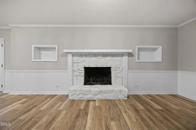 a view of empty room with wooden floor and fireplace