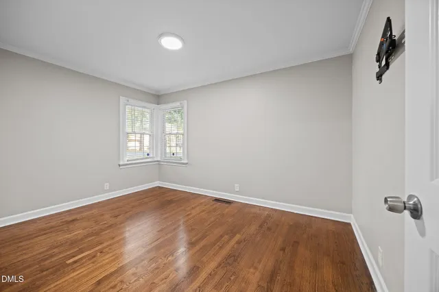 wooden floor in an empty room with a window