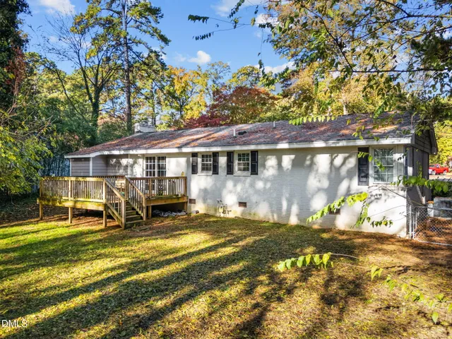 a view of a house with floor to ceiling windows and a big yard