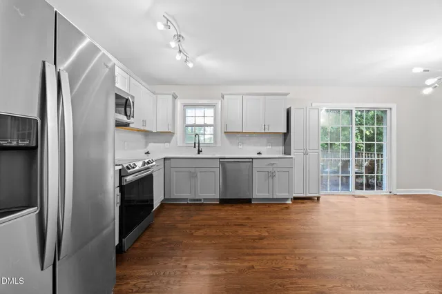 a kitchen with stainless steel appliances a refrigerator sink and cabinets