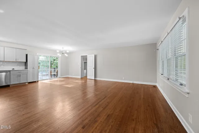 a view of empty room with wooden floor and window