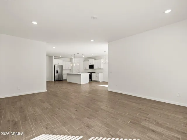 a kitchen with stainless steel appliances granite countertop a sink a stove a refrigerator and white cabinets