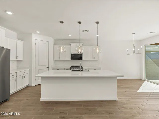 a kitchen with granite countertop a stove a sink and a microwave