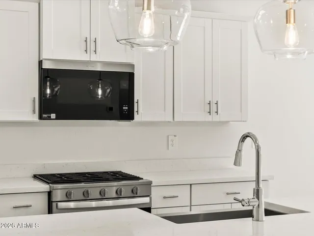 a kitchen with stainless steel appliances granite countertop a sink a stove and a refrigerator