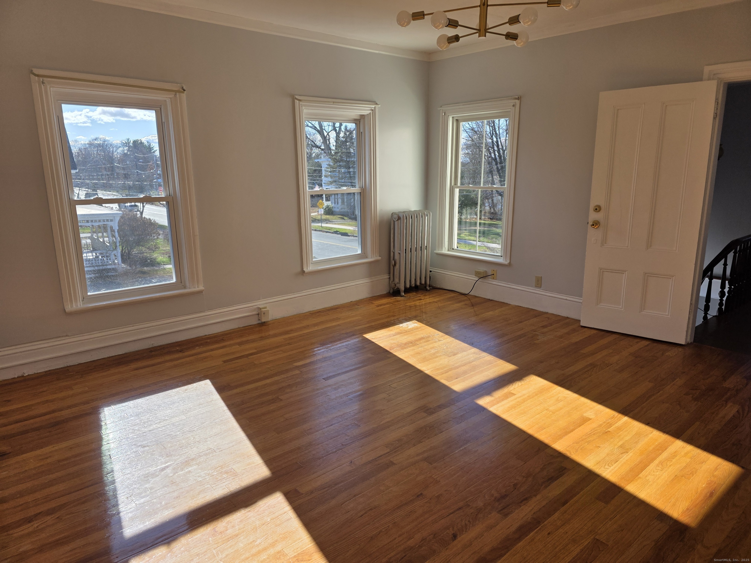 147 Pearl Street Enfield, CT 06082 - Photo 13 of 16 a view of an empty room with wooden floor and a window