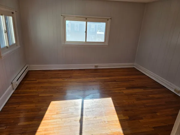 a view of a room with wooden floor and window