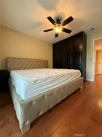 a bedroom with a bed and a ceiling fan
