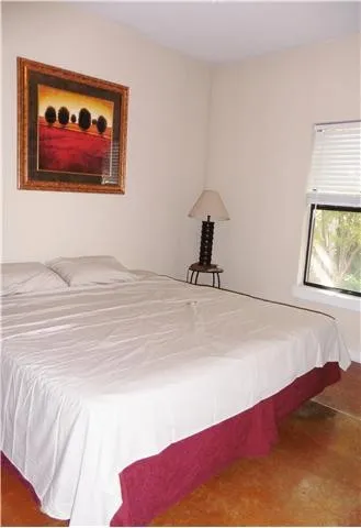 a bedroom with a bed and a painting on the wall