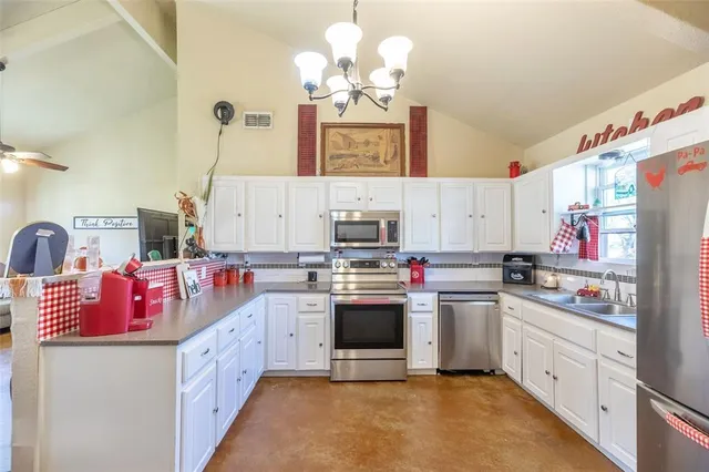 a kitchen with kitchen island granite countertop a sink stainless steel appliances and cabinets
