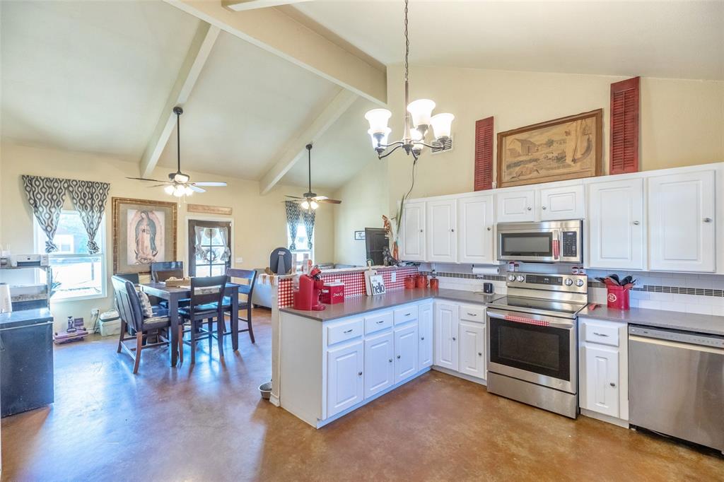 1502 Avenue North Anson, TX 79501 - Photo 14 of 20 a kitchen that has a lot of white cabinets and stainless steel appliances