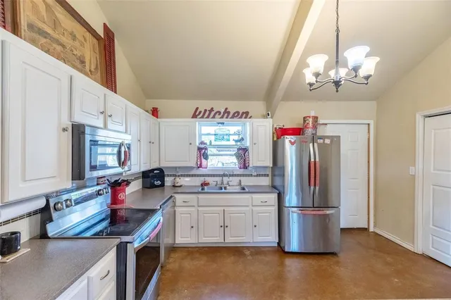 a kitchen that has a lot of cabinets and stainless steel appliances
