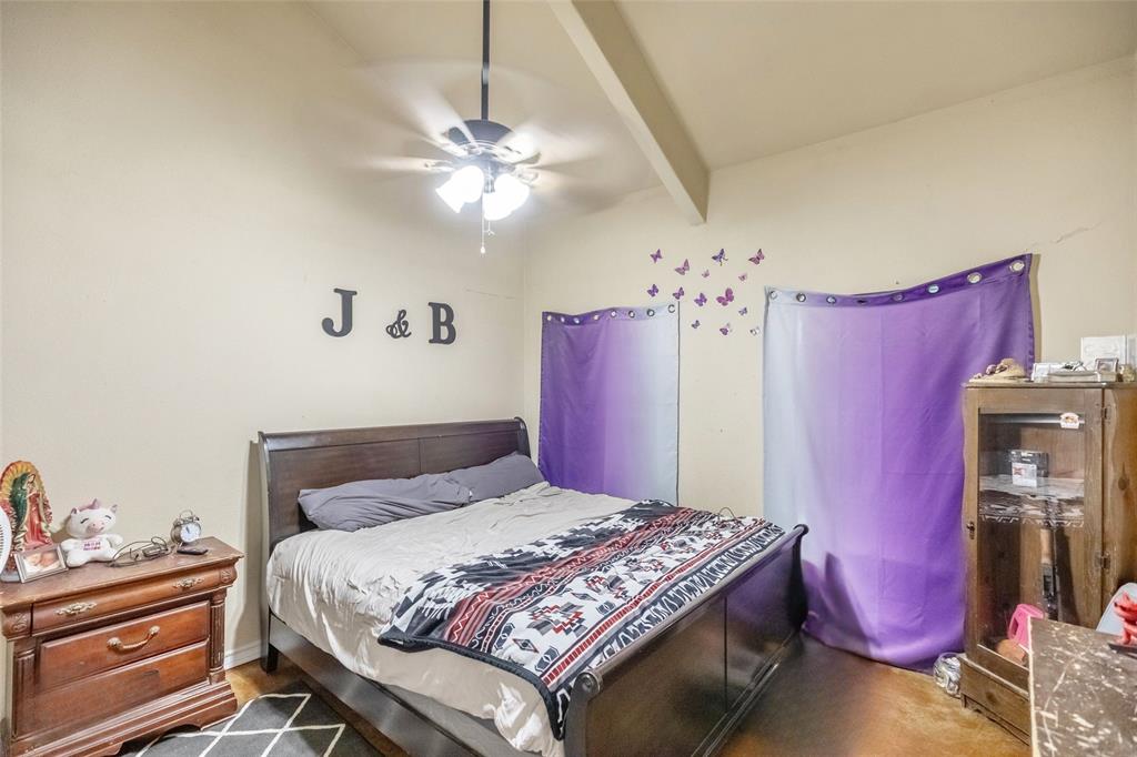 1502 Avenue North Anson, TX 79501 - Photo 16 of 20 a bedroom with a bed and a chandelier