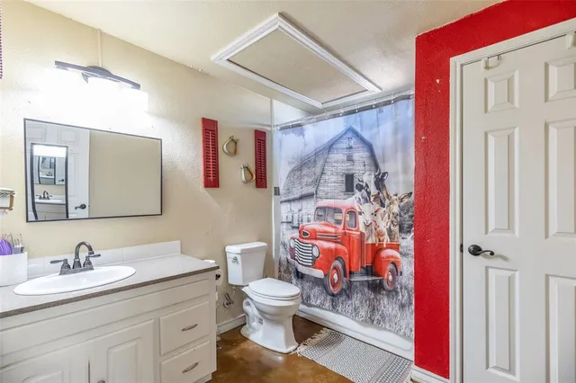 a bathroom with a granite countertop sink mirror vanity and toilet