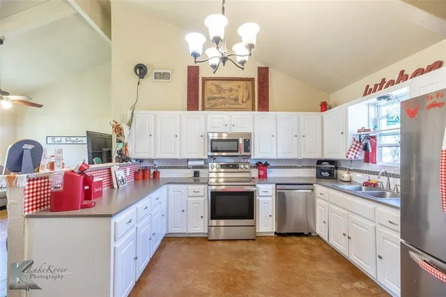 a kitchen with kitchen island granite countertop a sink stove and cabinets