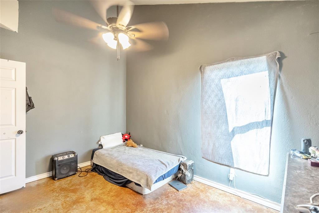 1502 Avenue North Anson, TX 79501 - Photo 10 of 20 a bedroom with a bed and a chandelier