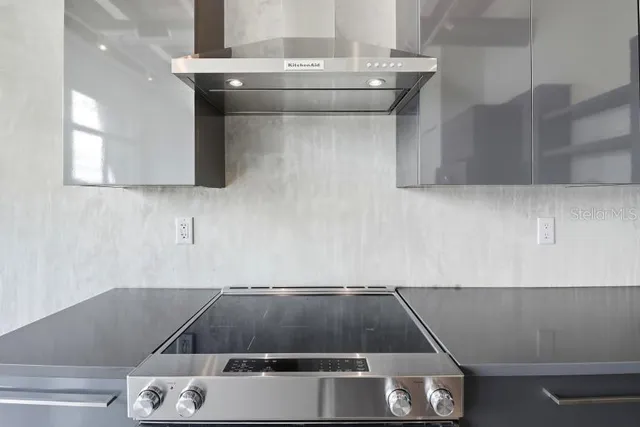 a large kitchen with stainless steel appliances kitchen island granite countertop a refrigerator and a stove top oven