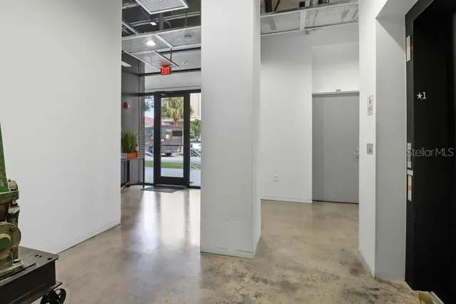 a view of a hallway with wooden floor and windows