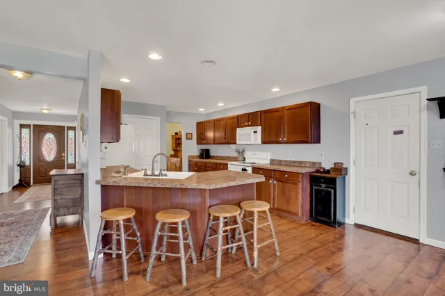 a kitchen with stainless steel appliances granite countertop a dining table chairs and granite counter tops