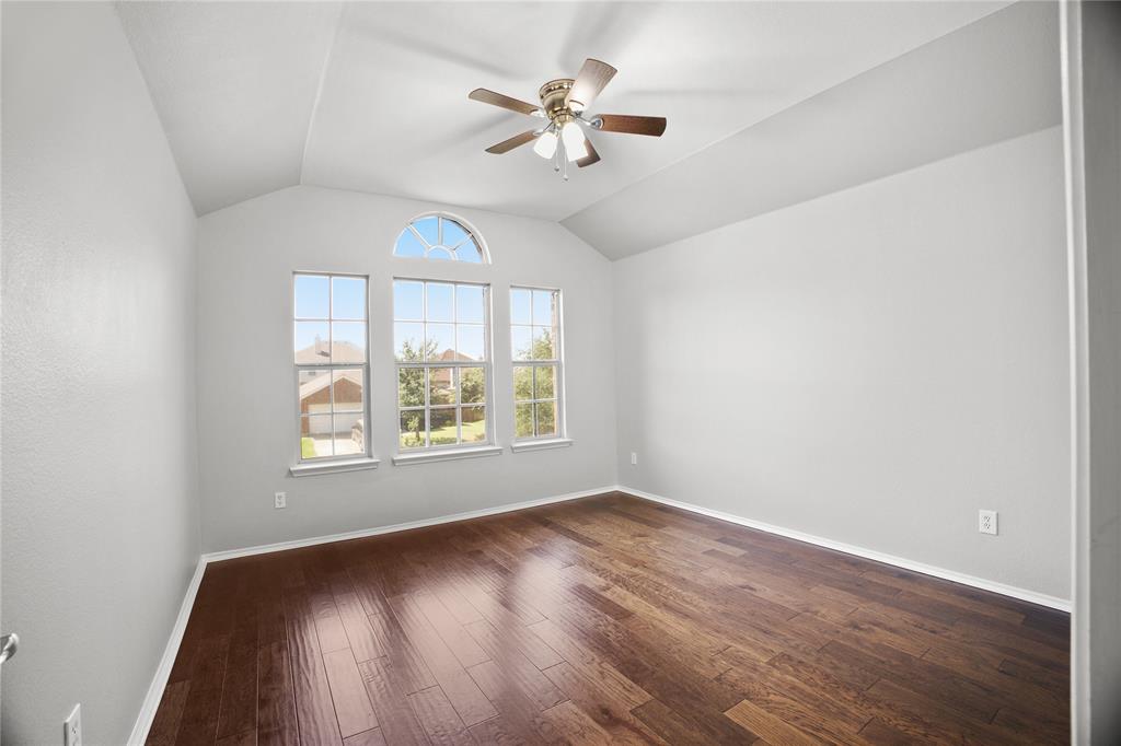 14904 Riverside Drive Little Elm, TX 75068 - Photo 18 of 28 an empty room with wooden floor chandelier fan and windows