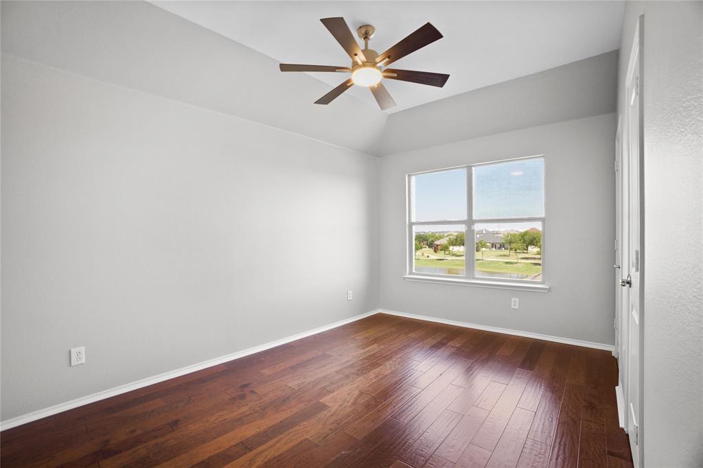 14904 Riverside Drive Little Elm, TX 75068 - Photo 19 of 28 an empty room with wooden floor and ceiling fan