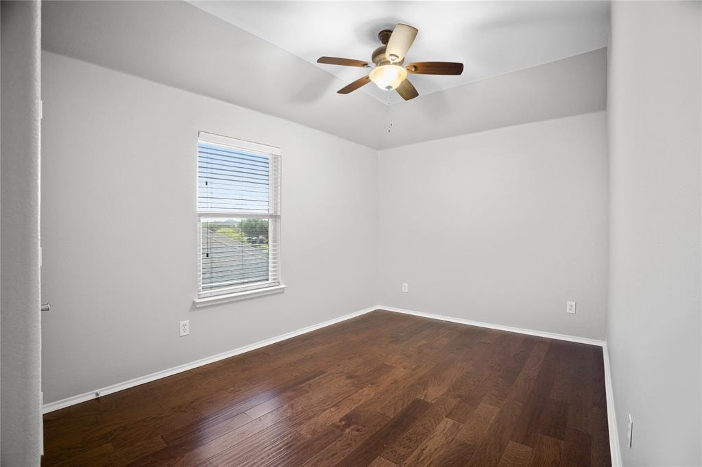 14904 Riverside Drive Little Elm, TX 75068 - Photo 20 of 28 an empty room with wooden floor ceiling fan and window