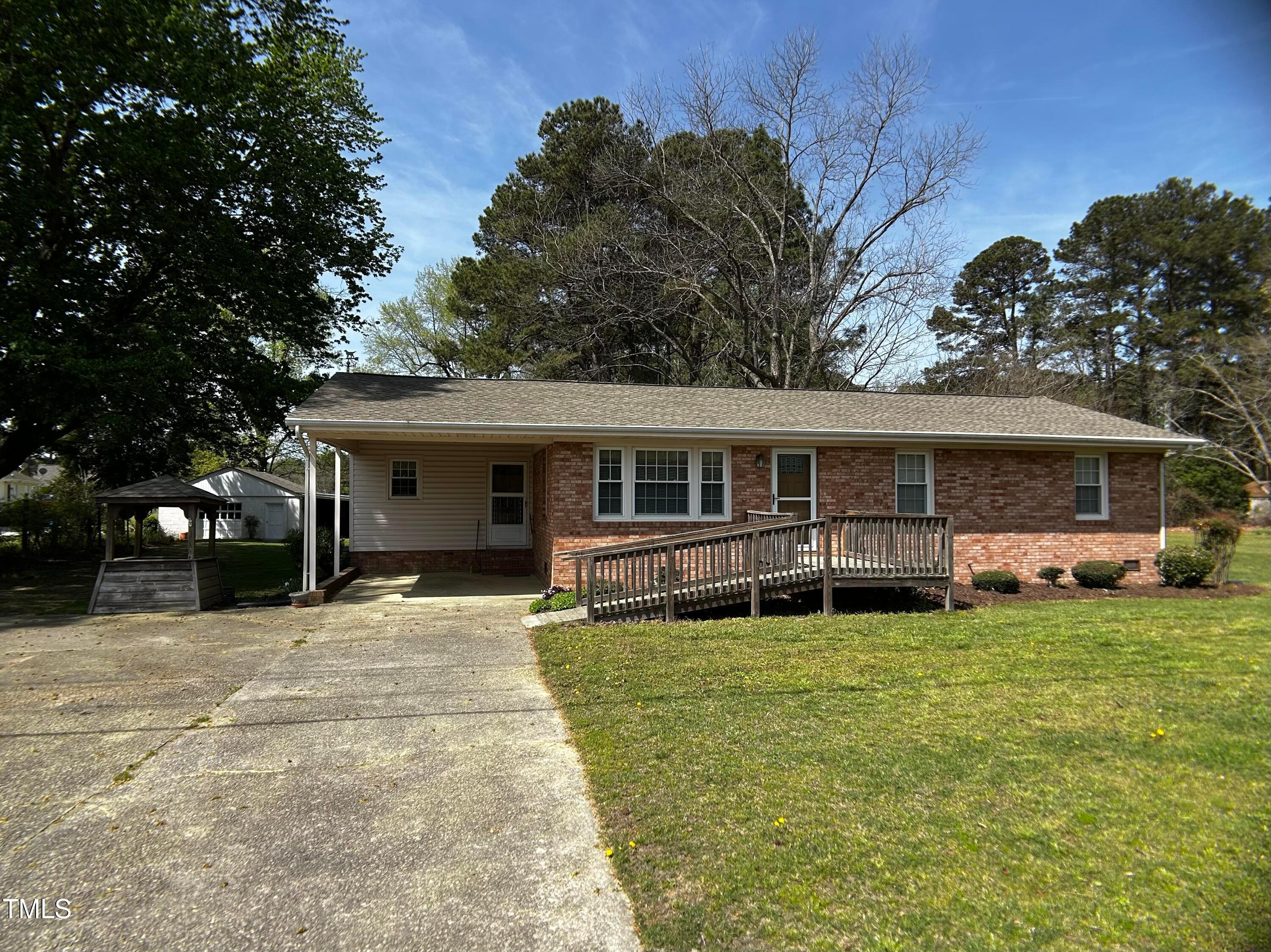 a front view of a house with a garden and trees