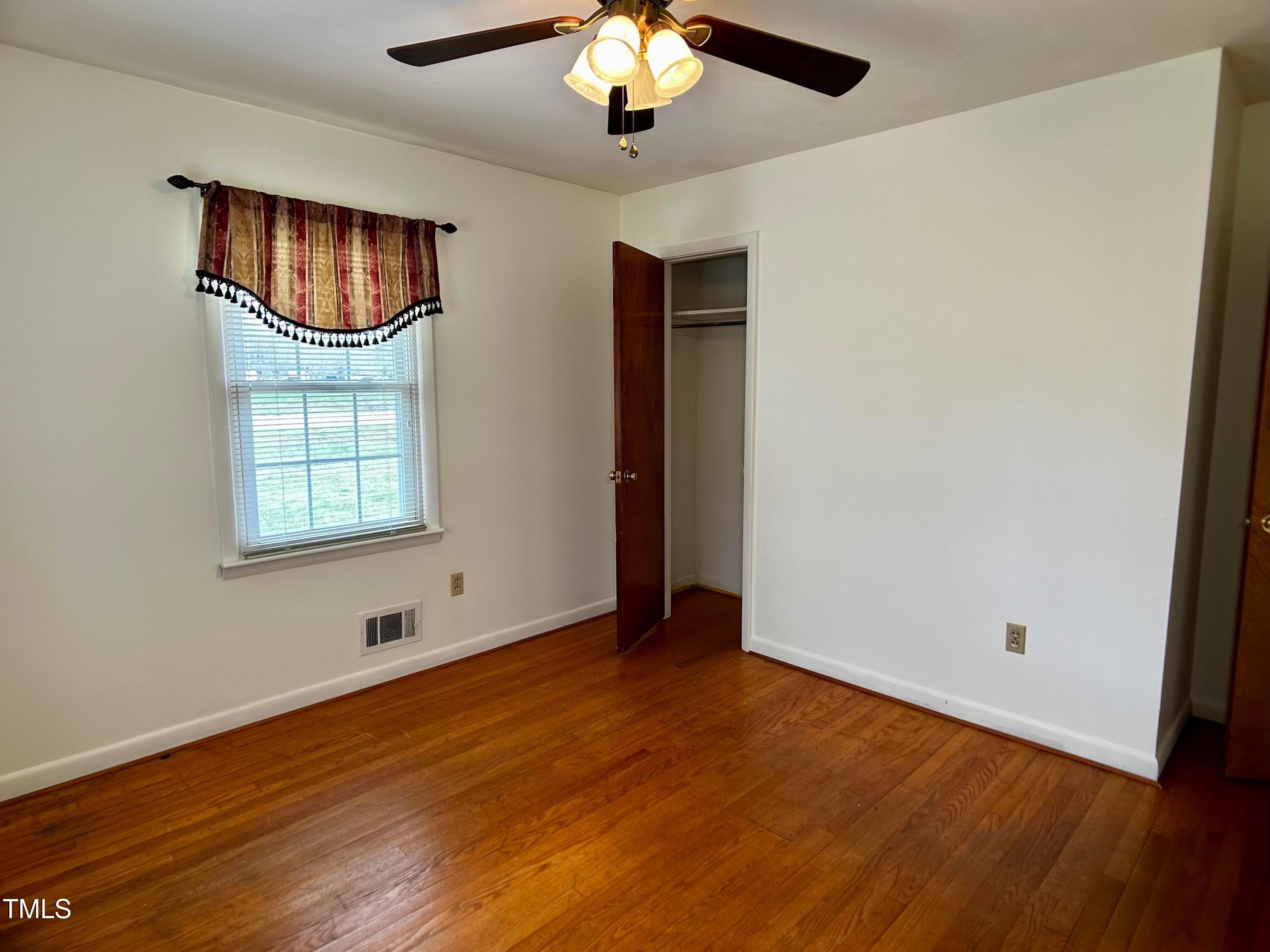 2981 Barber Mill Road Clayton, NC 27520 - Photo 11 of 28 an empty room with wooden floor chandelier and windows