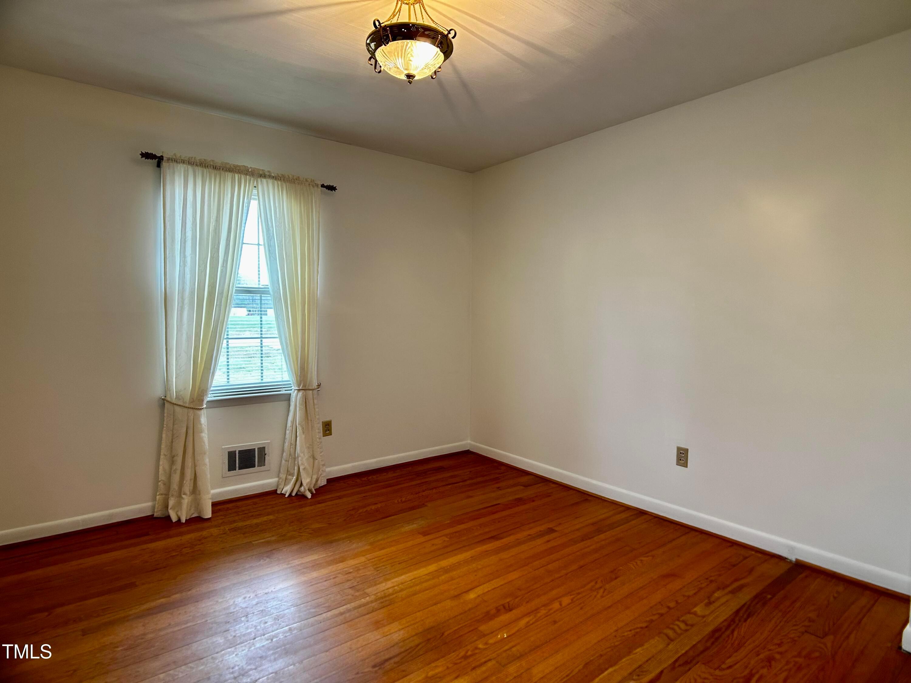 2981 Barber Mill Road Clayton, NC 27520 - Photo 12 of 28 an empty room with wooden floor and windows