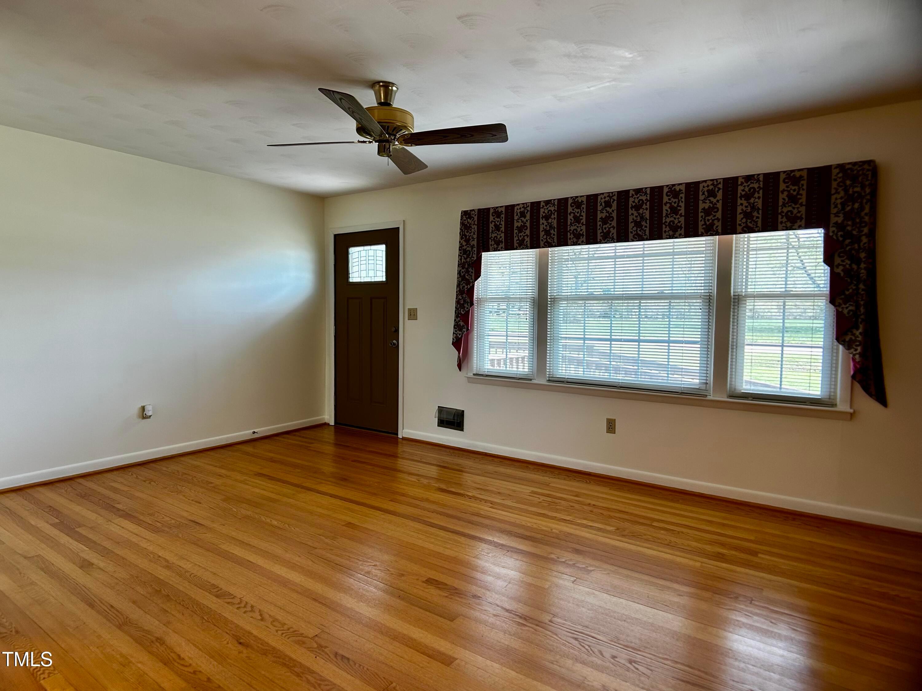 2981 Barber Mill Road Clayton, NC 27520 - Photo 4 of 28 a view of an empty room with wooden floor and a window