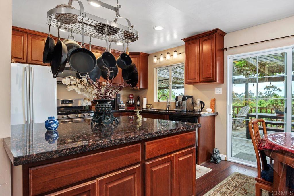 1107 Prospect Circle Vista, CA 92081 - Photo 11 of 52 a kitchen with stainless steel appliances granite countertop a sink a stove and a wooden cabinets