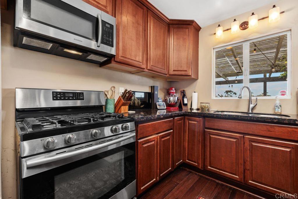 1107 Prospect Circle Vista, CA 92081 - Photo 13 of 52 a kitchen with stainless steel appliances granite countertop a stove and a microwave