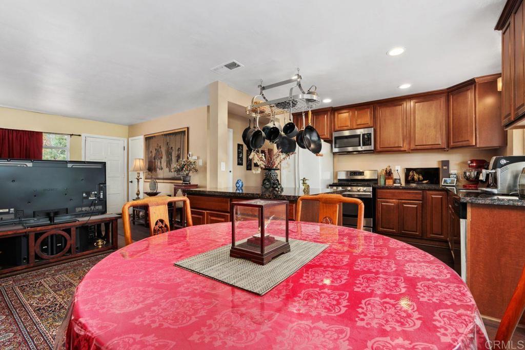 1107 Prospect Circle Vista, CA 92081 - Photo 10 of 52 a kitchen with kitchen island granite countertop a stove a sink a refrigerator dining table and chairs