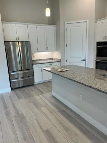 a kitchen with granite countertop a refrigerator sink and stove