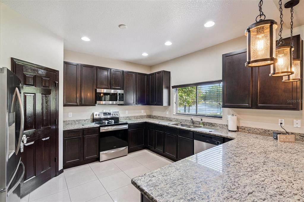 127 Verde Way DeBary, FL 32713 - Photo 13 of 83 a kitchen with stainless steel appliances granite countertop a sink stove and refrigerator