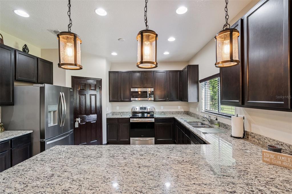 127 Verde Way DeBary, FL 32713 - Photo 25 of 77 a kitchen with stainless steel appliances kitchen island granite countertop a sink stove and refrigerator
