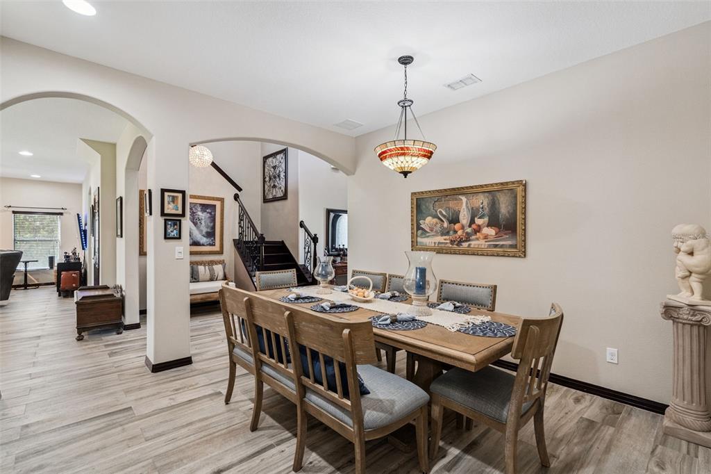 127 Verde Way DeBary, FL 32713 - Photo 5 of 77 a dining room with wooden floor a chandelier a wooden table and chairs