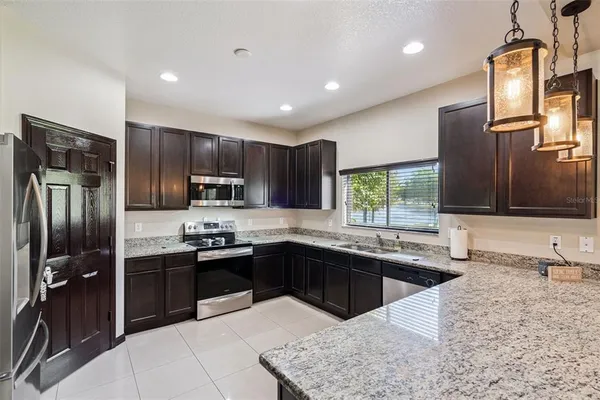 a kitchen with stainless steel appliances granite countertop a refrigerator and a sink