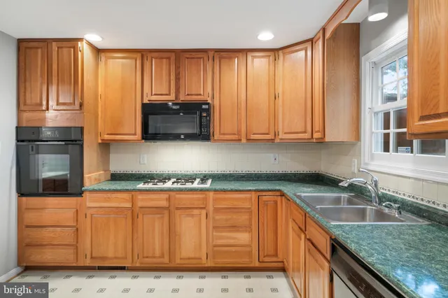 a kitchen with granite countertop a sink a stove and cabinets
